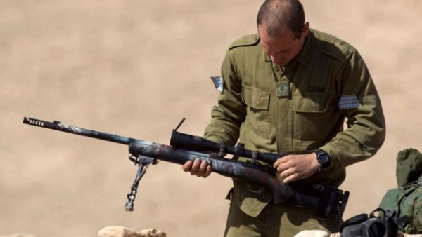 Israeli soldiers cheer as sniper shoots unarmed Palestinian near the border fence in the besieged Gaza Strip (AFP/ File Photo)