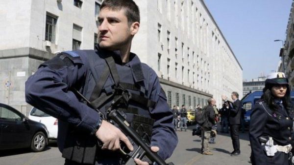 Police officers stand guard outside a court in Milan. (AFP/File)