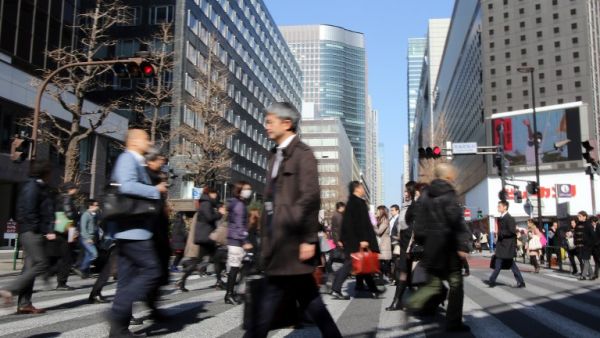 People cross an intersection in Tokyo (AFP/File Photo)	