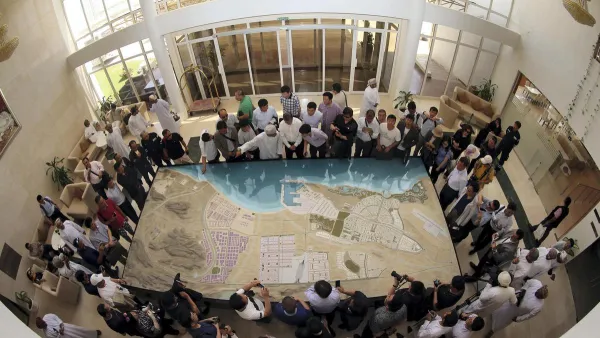 A picture taken with a fish-eye lens shows Chinese investors listening to an explanation as they check the model of the dry dock which is to be built following an economic agreement, on May 24, 2016 in the Omani port city of Duqm. Mohammed Mahjoub /AFP Photo