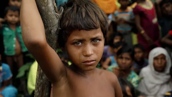A Rohingya refugee girl looks next to newly arrived refugees who fled to Bangladesh from Myanmar in Ukhiya on September 6, 2017. /AFP