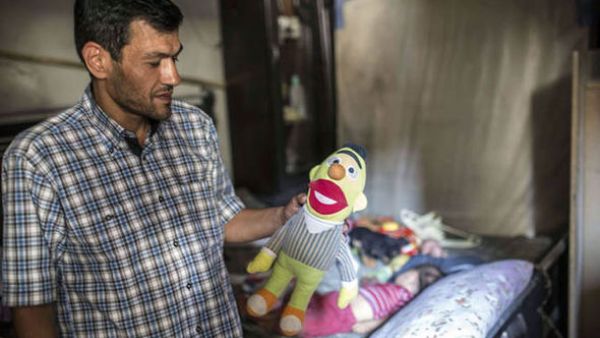 Man hold toys in memory of lost children (AFP/File Photo)	