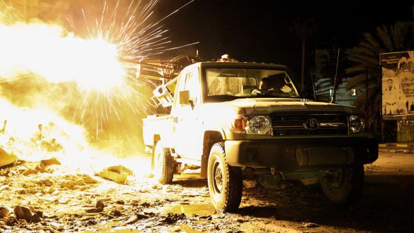 A member of the Libyan National Army, a militia group, fires a machine gun mounted on a pickup truck, Benghazi, 26 March 2017. (AFP/Abdullah Doma)