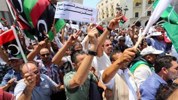 Protesters shout slogans waving national flags during a demonstration on Algeria Square to demand the removal of arms and the evacuation of unofficial armed groups on July 7, 2013 in the Libyan capital Tripoli.(MAHMUD TURKIA /AFP) Protesters shout slogans waving national flags during a demonstration on Algeria Square to demand the removal of arms and the evacuation of unofficial armed groups on July 7, 2013 in the Libyan capital Tripoli.(MAHMUD TURKIA /AFP)