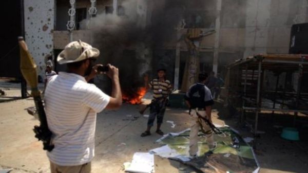 ثوار ليبيون يلتقطون صورا تذكارية في مجمع باب العزيزية في طرابلس