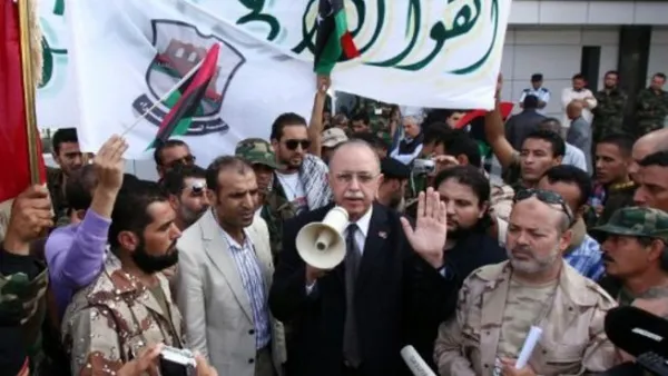 عبد الرحيم الكيب المكلف بتشكيل الحكومة الانتقالية يتوسط مجموعة من المقاتلين