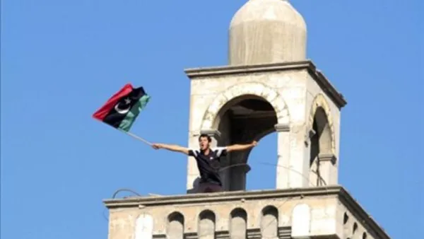  ليبي يرفع علم المعارضة فوق أحد مأذنة مسجد في مدينة الزاوية القريبة من العاصمة طرابلس