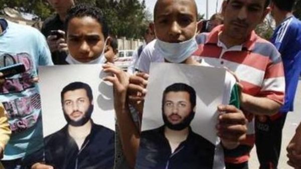 شابان يحملان صورة لسيف العرب القذافي في طرابلس يوم الاحد.
