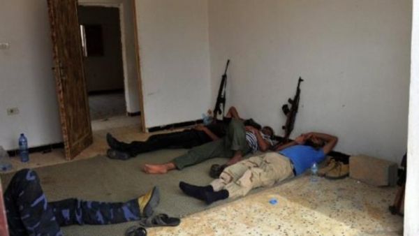 مقاتلون من المجلس الإنتقالي يستلقون في أحد منازل سرت