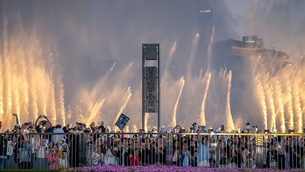Lareg crowds watch as The Dubai Fountain performs Power by EXO
