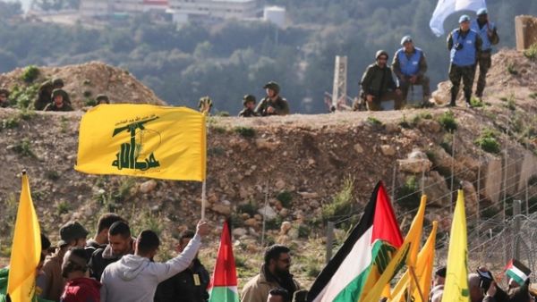 Hizbollah supporters hoist their flags as part of the elections campaign Lebanon is going through (AFP/File Photo)	