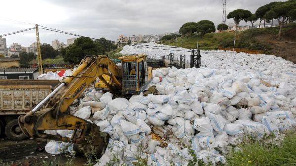 Workers use a front-loader to move piles of garbage from Jdeideh, a Beirut suburb, to the country's largest landfill of Naameh, just south of the Lebanese capital, on March 20, 2016.  (AFP/Anwar Amro)