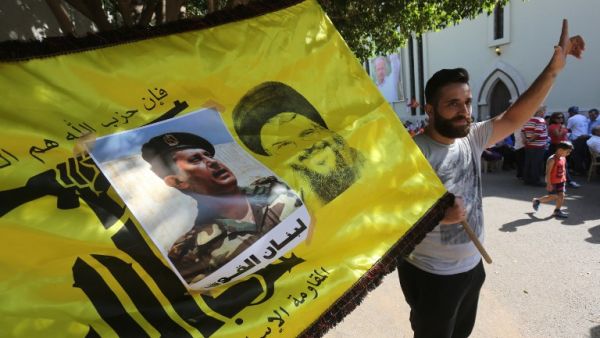 Supporters of Lebanon's Free Patriotic Movement celebrate the election of their leader MP Michel Aoun (portrait) and carry the flag of Hezbollah in the town of Jdeideh north of Beirut on October 31, 2016. (AFP/Marwan Tahtah)