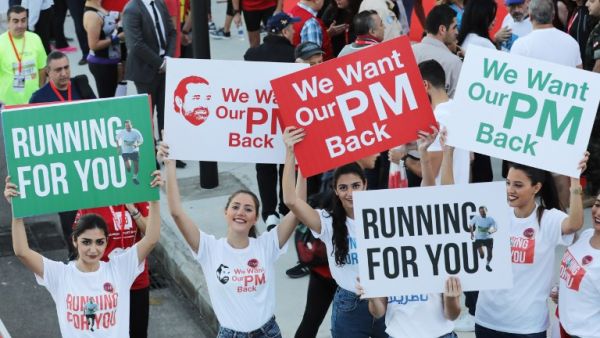 Supporters of Lebanon's resigned prime minister Saad Hariri hold up placards demanding his return from Saudi Arabia on the starting line of Beirut's annual marathon on November 12, 2017 (Anwar Amro/AFP) Supporters of Lebanon's resigned prime minister Saad Hariri hold up placards demanding his return from Saudi Arabia on the starting line of Beirut's annual marathon on November 12, 2017 (Anwar Amro/AFP)