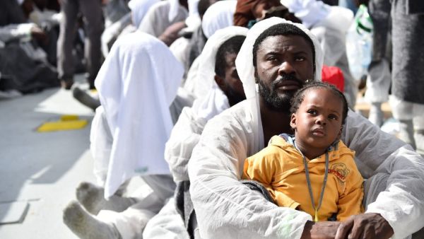 A father and daughter wait for aid distribution aboard a rescue ship, after their boat capsized off the coast of Libya. (AFP/Gabriel Bouys)