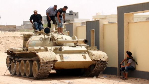 Forces with the National Unity Government stand on a tank in Sirte, Libya, during a land-and-air campaign to retake the city from Daesh. (AFP/Stringer)