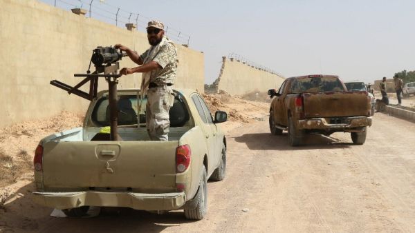 A fighter from forces loyal to Libya's Government of National Unity (GNA) stands on a truck mounted with a machine gun as he holds a position in Sirte during an operation to recapture the coastal city from Daesh, on July 2, 2016. (AFP/Mahmud Turkia)