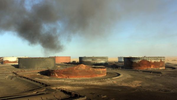 This file photo taken on January 08, 2016 shows smoke billowing from a petroleum storage tank after a fire was extinguished at Al-Sidra oil terminal, near Ras Lanuf, in the so-called "oil crescent" along Libya's northern coast. (AFP/Stringer