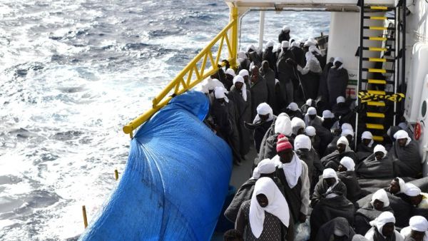 Migrants protect themselves from the cold with blankets as they wait to arrive in the port of Cagliari, Sardinia, on May 26, 2016 aboard the rescue ship "Aquarius", two day after their rescue off the Libyan coasts. (AFP/Gabriel Bouys)