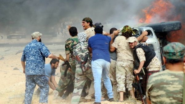 Forces loyal to Libya's UN-backed unity government attempt to evacuate a passenger stuck inside a vehicle following a car-bomb attack carried out by Daesh near Sirte on June 2, 2016. (AFP/Mahmud Turkia)