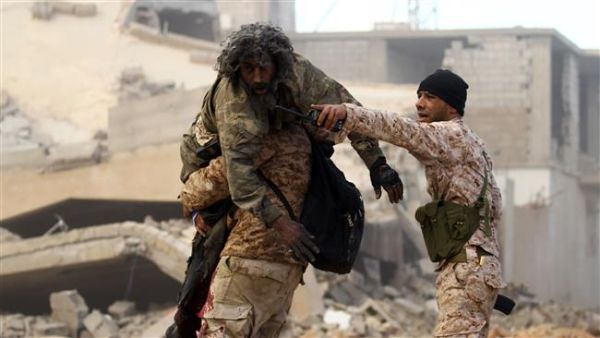 A member of the Libyan National Army (LNA) carries an injured comrade during fighting against Daesh Takfiri terrorists in the southern areas of Benghazi. (AFP/ File Photo)