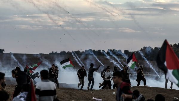 Palestinians react to tear gas fired by Israeli forces during a protest on November 23, 2018 in Gaza. (MAHMUD HAMS / AFP)