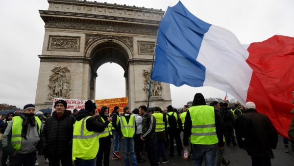 Protesters stand holding a French flag near the Arc de Triomphe on the Place de l'Etoile in Paris during an anti-government demonstration. (AFP)