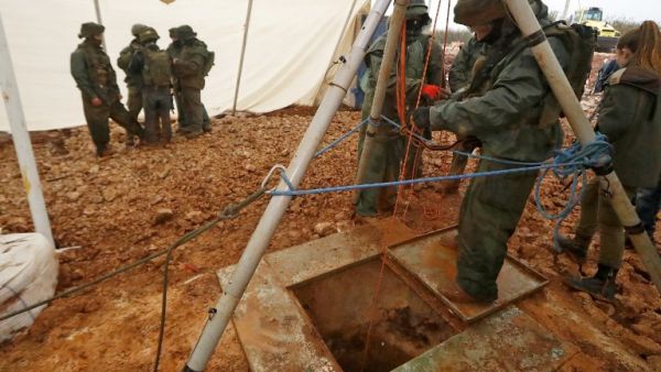 An Israeli soldier operating a pulley while standing outside an entry point made by the army to intercept a tunnel which reportedly connects between Lebanon and Israel, near the border. (AFP/File)
