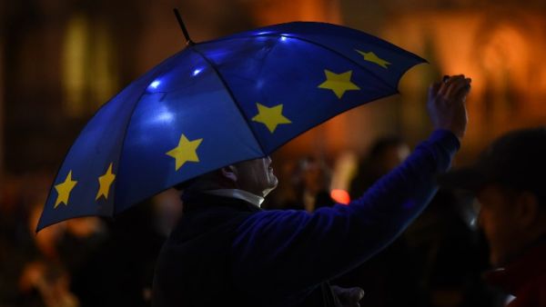 A Pro-EU anti-Brexit protsters with an umbrella decorated in teh style of the EU flag is seen outside the Houses of Parliament in central London. (AFP/ File)