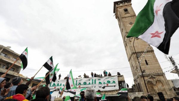 Syrians demonstrate with opposition flags in the square of the Great Mosque of the city of Maaret al-Numan in the south of the mostly rebel-held Idlib province on March 15, 2019. (AFP/ File Photo)
