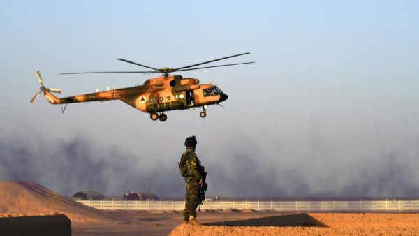 An Afghan Commandos stands guard while an Afghan Air Force helicopter flies past during a combat training exercise at the Shorab Military Camp in Helmand province. (AFP)
