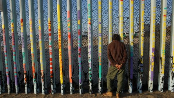  A man looks through the U.S.-Mexico border wall in the Las Playas area on January 6, 2019 in Tijuana, Mexico. (AFP/File)