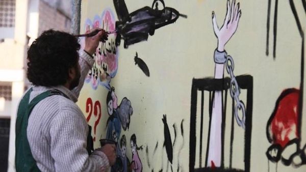 Syrian artist Aziz al-Asmar works on a mural depicting the war ahead of the start of the Astana peace talks. (AFP/ File Photo)