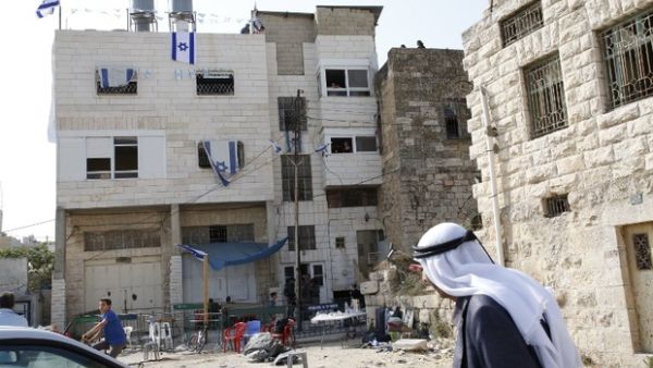 Palestinians walk past a house occupied by a group of Israeli settlers the previous day in the divided West Bank town of Hebron. (AFP)
