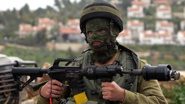 An Israeli soldier holds his weapon during clashes with Palestinian protesters in West Bank. (AFP Photo/Abbas Momani)
