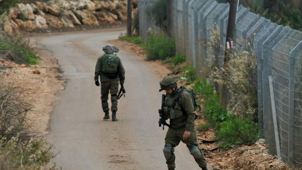 An Israeli soldier stands behind a laid-out spike strip at a security checkpoint near the northern Israeli town of Metula near the border with Lebanon on December 4. (AFP/File)
