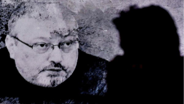 A man passes in front of a screen showing Jamal Kashoggi during a commemoration event of Khashoggi's supporters on November 11 in Istanbul. (AFP)