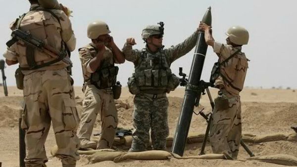 A US military adviser helps soldiers from the 17th Iraqi army brigade load a mortar. (AFP/ File)
