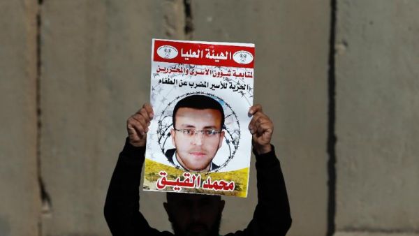 A Palestinian protester hold a poster with Mohammed al-Qiq's face. (AFP/Abbas Momani)