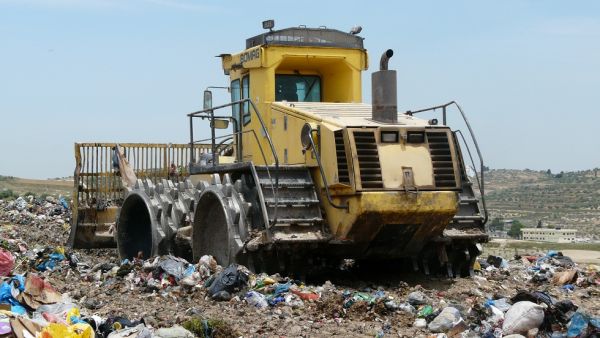 جرافة تقوم بطمر نفايات في مكب زهرة الفنجان