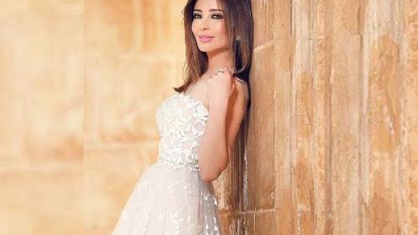 جاء الفستان بلون الأوف وايت بكتفين مفتوحين من الدانتيل