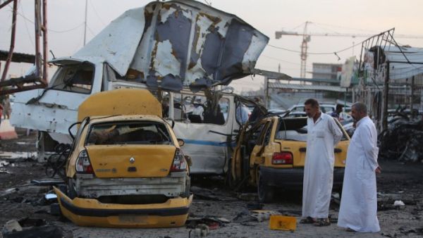 Two men inspect the site of a car bomb that went off in the mostly Shia Sadr City district of Baghdad on October 13, 2014. (AFP/Ahmad al-Rubaye)