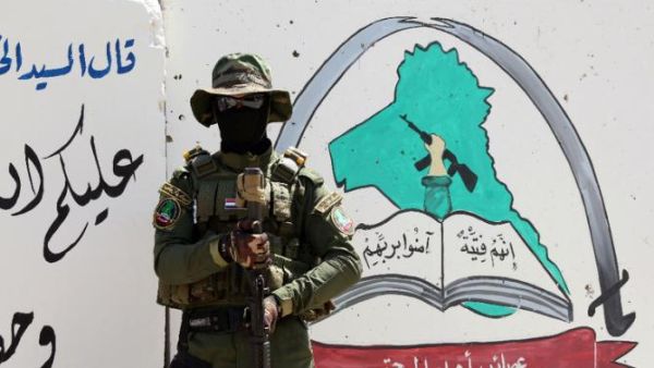An Iraqi fighter of the Shia militia Asaib Ahl al-Haq (The League of the Righteous) stands guard outside the militia's headquarters in Basra, on May 18, 2015. (AFP/Haidar Mohammed Ali)
