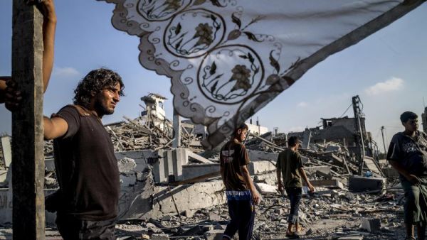 Palestinians stand next to a makeshift shelter in Gaza City on 6 August 2014. (AFP/File)