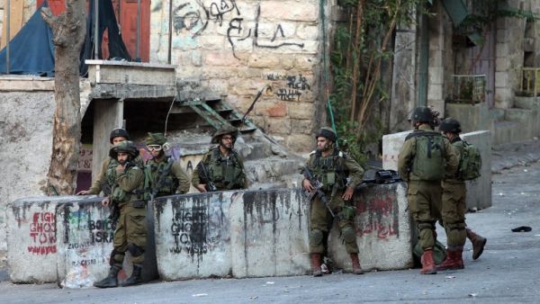 IDF soldiers stand guard near the site where a Palestinian attempted to stab a soldier. (AFP/File)