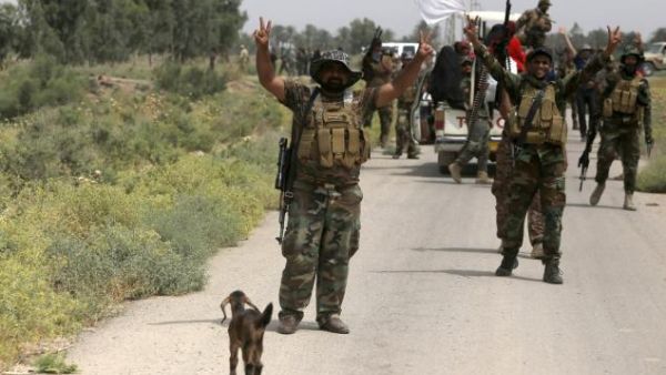 Iraqi pro-government militiamen flash the sign of victory celebrating after the liberation from Daesh militants of the village of Sayed Ghareeb, near Dujail, on Tuesday. (AFP/Mohammed Sawaf)