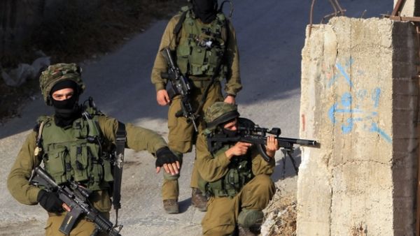 Israeli soldiers hold a position in a street, east of the West Bank city of Nablus, on 3 October 2015. (AFP/File)