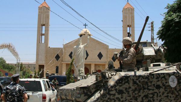 Lebanese soldiers stand guard in front of a church where a suicide bomber blew himself up the previous day in the Christian village of al-Qaa. (AFP/File)