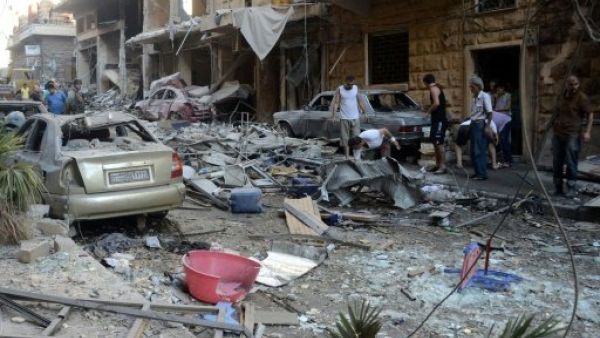 Syrians look at the damage in the Syriac Quarter of the regime-held area of Aleppo, following a rocket attack by rebels, on July 11, 2016. (AFP/File)