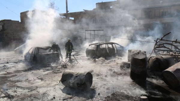 Syrian fire fighters put out a blaze at the scene of a reported barrel bomb strike. (AFP/File)